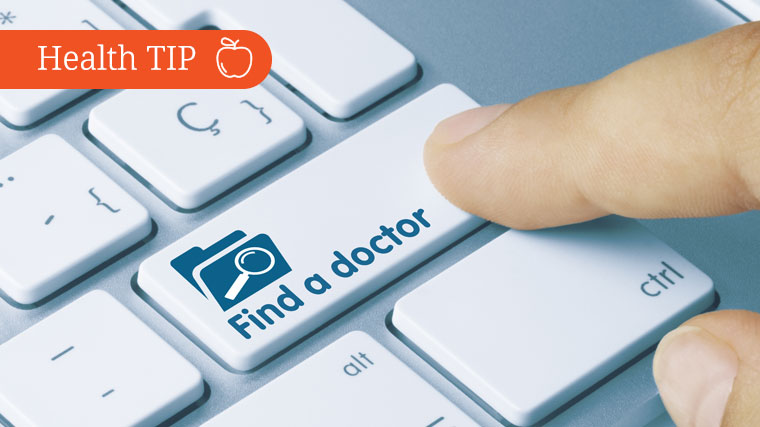 A person's finger touches a computer key that reads "Find a doctor"