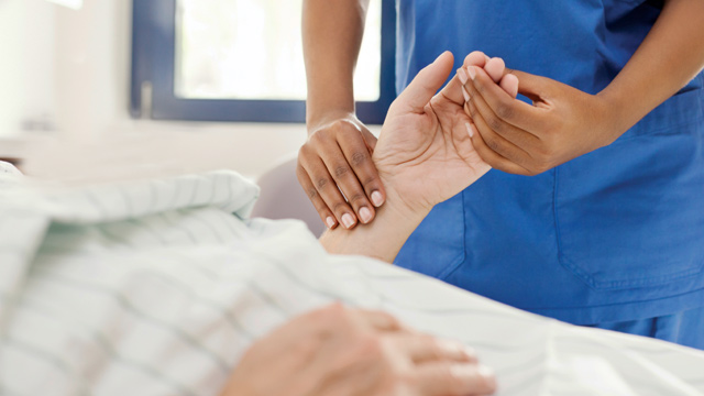 P-W-WMN73405-Rabies-Quiz-stack Provider gently evaluates a patient's left hand